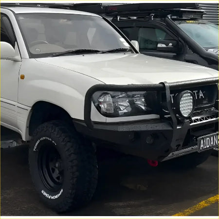 White Toyota Land Cruiser 105 with black GT hoop bullbar and rock sliders from Rockarmor Rock Pack for off-road use