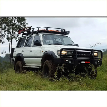White toyota land cruiser fj80 with black metal bullbar and roof rack from rockarmor rock pack premium set